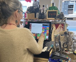 woman using charity shop epos till